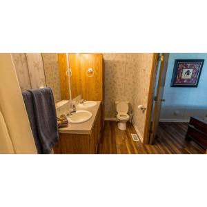 ein Badezimmer mit einem Waschbecken, einem WC und einem Spiegel in der Unterkunft Shady Shores RV Resort & Campground 