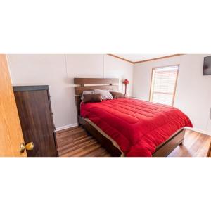 a bedroom with a bed with a red blanket at Shady Shores RV Resort & Campground 