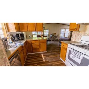 a kitchen with wooden cabinets and a stove top oven at Shady Shores RV Resort & Campground 