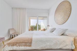 biała sypialnia z dużym łóżkiem i oknem w obiekcie Stylish apartment with oceanview w Maladze +16 zdjęć