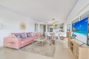 salon z różową kanapą i telewizorem w obiekcie Stylish apartment with oceanview w Maladze