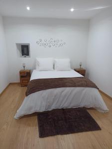 a bedroom with a large bed with a wooden floor at A Casa da Carmita in Pedrógão Grande +40 photos