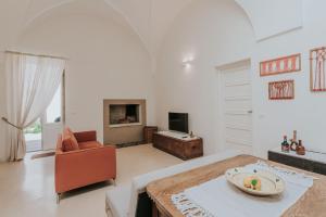 Volte_sotto_le_stelle في كازارانو: غرفة معيشة بيضاء مع طاولة وكرسي