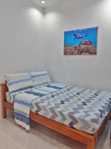 Jah’s Anemone Dive Guesthouse في موالبوال: غرفة نوم بسرير مع صورة على الحائط