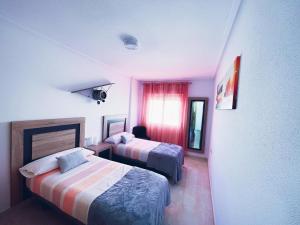 a hotel room with two beds and a window at HomeXperience in San Pedro del Pinatar +22 photos