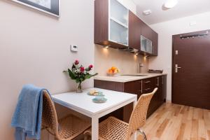 a kitchen with a white table and chairs at Apartamenty Bałtycka by Renters in Świnoujście