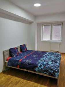 - une chambre avec un lit et une couverture bleue dans l'établissement VD Apartment, à Skopje