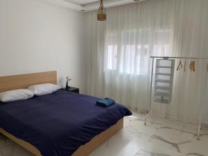 1 dormitorio con 1 cama con manta azul y escalera en Sun of rabat en Rabat