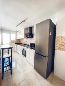 a kitchen with a stainless steel refrigerator and a table at HomeXperience in San Pedro del Pinatar