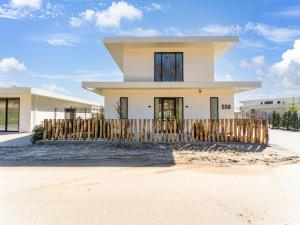 een huis met een houten hek ervoor bij Modern water villa in Zeewolde with jetty in Zeewolde