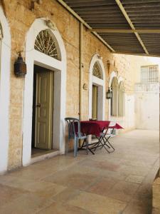 Traditional House with Amazing Veranda في بيت لحم: فناء مع طاولة وكراسي في مبنى