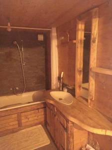 uma casa de banho com um lavatório, uma banheira e um WC. em Appartement proche Villars em Panex