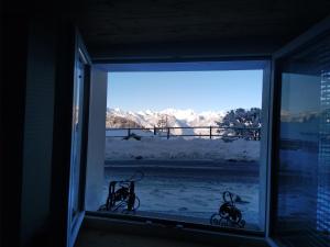 uma janela com duas bicicletas sentadas no parapeito da janela em Appartement proche Villars em Panex