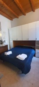 Un dormitorio con una gran cama azul con almohadas blancas en a casa di Max, en Trezzo sullʼAdda