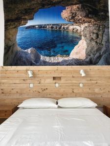 a bedroom with a bed with a painting on the wall at Antonis Hotel in Kefalos