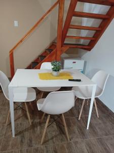 una mesa blanca y sillas con una planta en Duplex Franisa, en El Calafate