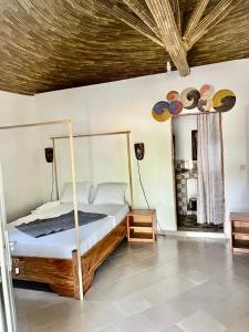 een slaapkamer met een bed met een houten frame bij Abené shuDyma lodge in Abémé