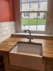 a white sink in a kitchen with a window at The Coach House, Hesket Newmarket in Hesket Newmarket