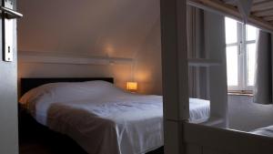 1 dormitorio con cama blanca y ventana en De Vitsemolenhoeve en Westouter