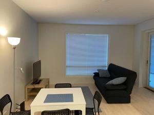 a living room with a couch and a table at Modern 1 bedroom apartment with a patio in Turku