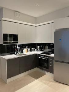 a kitchen with black and white cabinets and a refrigerator at Modern 1 bedroom apartment with a patio in Turku