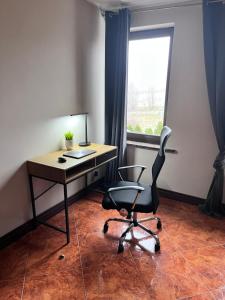 a desk and a chair in a room with a window at Apartamenty EverySky Gasthaus Karpacz in Karpacz