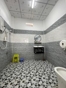 een badkamer met een douche, een wastafel en een spiegel bij Căn Hộ Nghĩ Dưỡng Tuấn Hải - Nhà Chị Hai in Bao Loc
