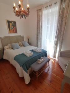 a bedroom with a large bed and a chandelier at OSBORNE GUEST HOUSE in Sintra +15 photos