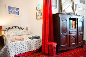 Schlafzimmer mit einem Bett und einer Kommode mit roten Vorhängen in der Unterkunft Family Apartment Old Town near Beach AC in Nizza