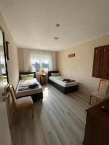 pokój z 2 łóżkami i 2 krzesłami w obiekcie Apartments Feniks w mieście Blomberg