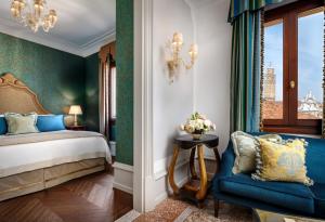 a bedroom with a bed and a blue chair at The Gritti Palace, a Luxury Collection Hotel, Venice in Venice