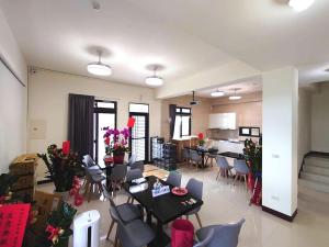 ein Wohnzimmer mit einem Tisch und Stühlen sowie eine Küche in der Unterkunft 別野城北 in Hsing-wen