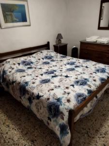 ein Schlafzimmer mit einem Bett mit einer blauen und weißen Decke in der Unterkunft Zara House in CastellʼAzzara