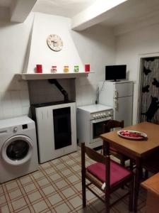 eine Küche mit einer Waschmaschine und einem Tisch mit Stühlen in der Unterkunft Zara House in CastellʼAzzara