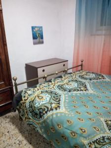 - une chambre avec un lit et une couette colorée dans l'établissement Zara House, à CastellʼAzzara