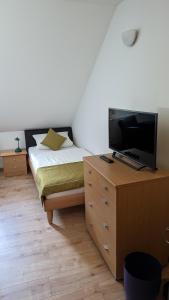 1 dormitorio con 1 cama y vestidor con TV en Gasthof zum Lehnerwirt, en Breitenbrunn