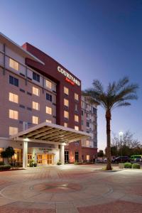 ein Hotel mit einer Palme vor einem Gebäude in der Unterkunft Courtyard Phoenix Chandler/Fashion Center in Chandler