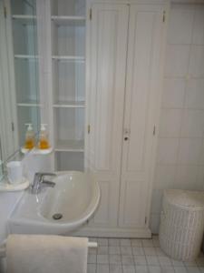 La salle de bains blanche est pourvue d'un lavabo et d'un miroir. dans l'établissement Lütje Gaadt 17 c, à Westerland