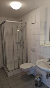 a bathroom with a shower and a toilet and a sink at Gasthof zum Lehnerwirt in Breitenbrunn