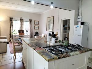 a kitchen with a stove top oven in a room at Olive and Vine Farm Cottage in Franschhoek