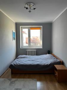 a bedroom with a bed and a window at Smak PRL-u in Ustka