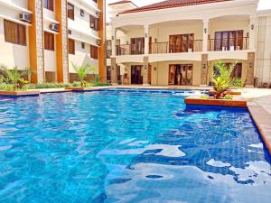 a swimming pool in front of a building at JCM- Studio Deluxe Room in Manila