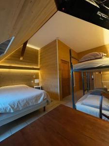 2 łóżka piętrowe w pokoju z drewnianymi ścianami w obiekcie Auberge des Sauterelles w mieście Sermersheim