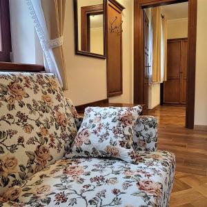 a living room with a couch with a flower pattern at Hotel Sarmata Zespół Dworski in Sandomierz