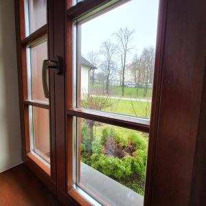 an open window with a view of a garden at Hotel Sarmata Zespół Dworski in Sandomierz