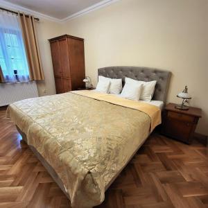 1 dormitorio con 1 cama grande y suelo de madera en Hotel Sarmata Zespół Dworski, en Sandomierz