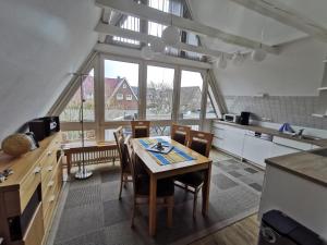 a kitchen with a table and chairs in a room at Lütje Gaadt 17 c in Westerland
