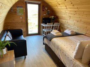 1 dormitorio con 1 cama en una cabaña de madera en Earls View Maxi Pod en Carna