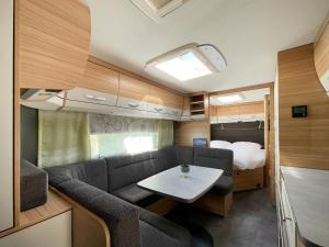 ein Wohnzimmer mit einem Sofa und einem Tisch in einem Wohnwagen in der Unterkunft Mietwohnwagen 03 in Heringsdorf