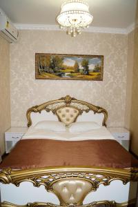 a gold bed in a bedroom with a chandelier at Marianna Hotel in Sochi